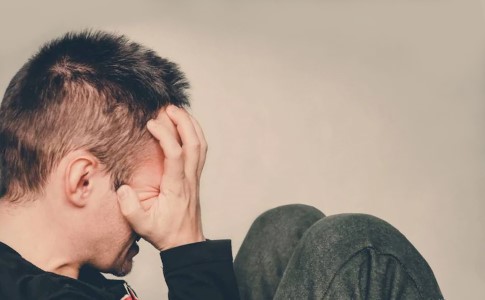 Побочное действие антидепрессантов Мужчина держится за голову